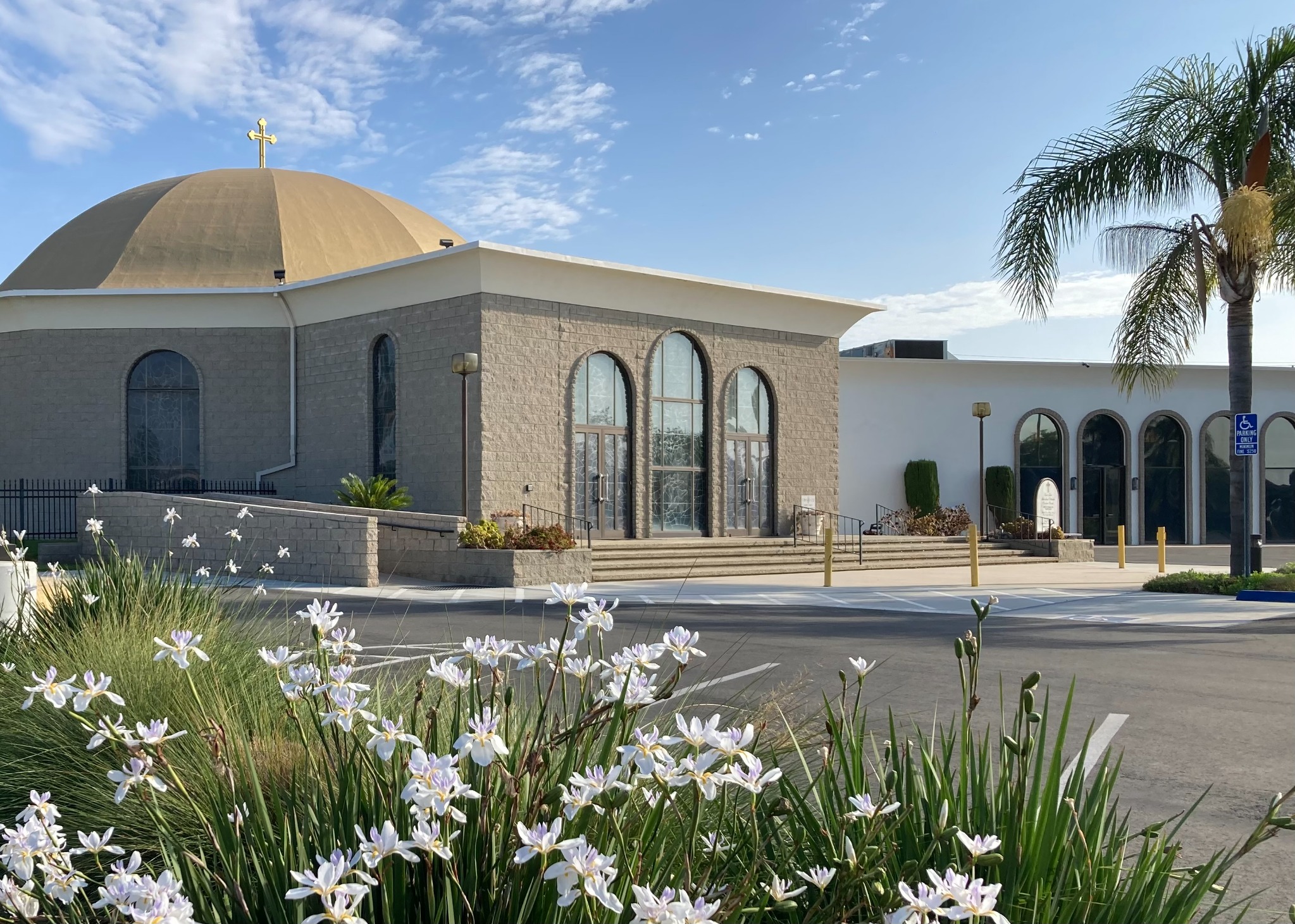 St. Luke Orthodox Church entrance with white flowers in the foreground